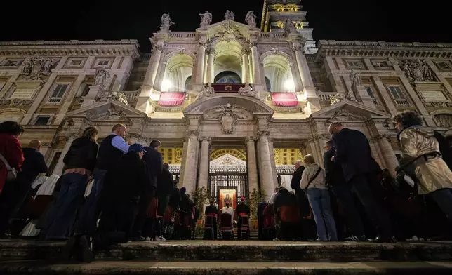 People attend a rosary prayer outside the Santa Maria Maggiore Basilica, where the late Pope Francis will be buried, in Rome, Thursday, April 24, 2025. (AP Photo/Andreea Alexandru)