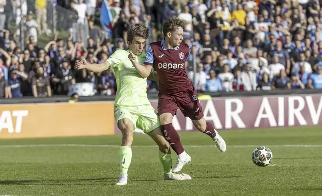 Barcelona's Andres Cuenca, left, fights for the ball with Trabzonspor's Onuralp Cakiroglu, right, during the UEFA Youth League Final match between Trabzonspor and Barcelona, at the Colovray Sports Centre in Nyon, Switzerland, Monday, April 28, 2025. (Salvatore Di Nolfi/Keystone via AP)