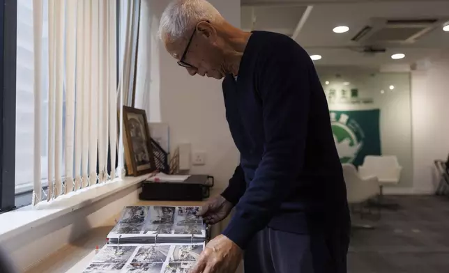 Yeung Sum, the founding member of the Democratic Party, looks through old pictures at the Democratic Party's office in Prince Edward in Hong Kong on April 2, 2025. (AP Photo/May James)