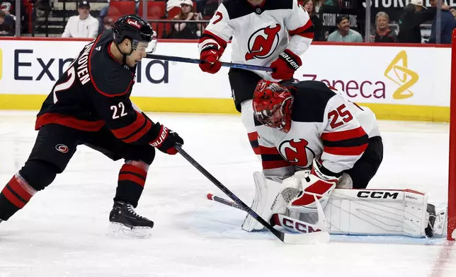 Carolina Hurricanes' Logan Stankoven (22) has his shot swallowed by New Jersey Devils goaltender Jacob Markstrom (25) during the second period of Game 2 of an NHL hockey Stanley Cup first-round playoff series in Raleigh, N.C., Tuesday, April 22, 2025. (AP Photo/Karl DeBlaker)