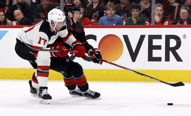 Carolina Hurricanes' Andrei Svechnikov (37) battles with New Jersey Devils' Simon Nemec (17) for control of the puck during the second period of Game 2 of an NHL hockey Stanley Cup first-round playoff series in Raleigh, N.C., Tuesday, April 22, 2025. (AP Photo/Karl DeBlaker)