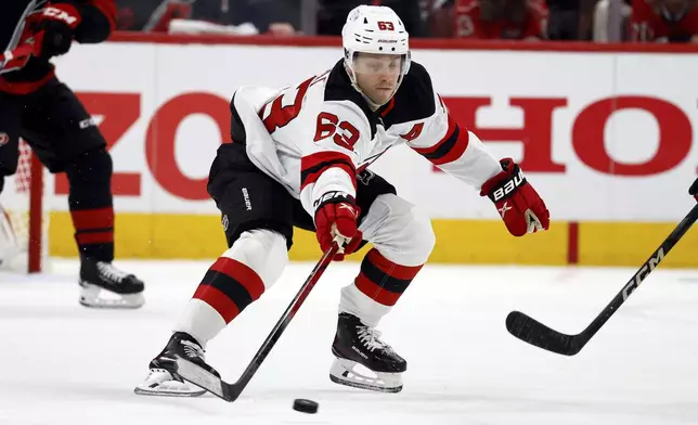 New Jersey Devils' Jesper Bratt (63) gathers in the puck against the Carolina Hurricanes during the first period of Game 2 of an NHL hockey Stanley Cup first-round playoff series in Raleigh, N.C., Tuesday, April 22, 2025. (AP Photo/Karl DeBlaker)