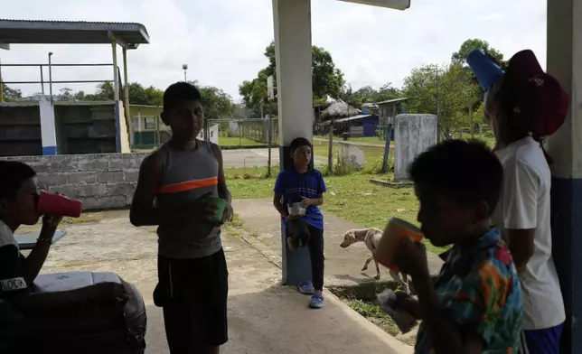 Children eat a snack during a break at school in Villa Caleta, a community in Panama that used to benefit economically by being on the route migrants took after crossing the Darien Gap on their way north to the U.S., Monday, April 7, 2025. (AP Photo/Matias Delacroix)