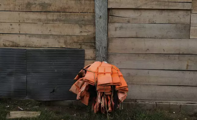 Lifejackets hang at the home of a local in Villa Caleta, Panama, Monday, April 7, 2025. The jackets were once used to ferry migrants after their trek across the Darien Gap on their way north to the U.S. (AP Photo/Matias Delacroix)