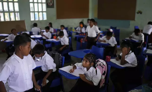 Students attend class in Villa Caleta, a community in Panama that used to benefit economically by being on the route migrants took after crossing the Darien Gap on their way north to the U.S., Monday, April 7, 2025. (AP Photo/Matias Delacroix)