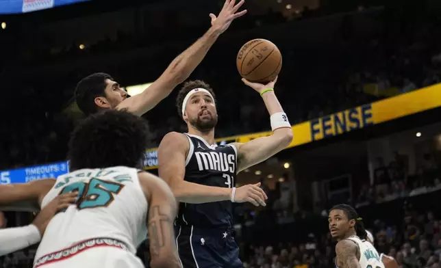 Dallas Mavericks guard Klay Thompson (31) shoots the ball past Memphis Grizzlies forward Santi Aldama, left, during the second half of an NBA play-in tournament basketball game Friday, April 18, 2025, in Memphis, Tenn. (AP Photo/George Walker IV)