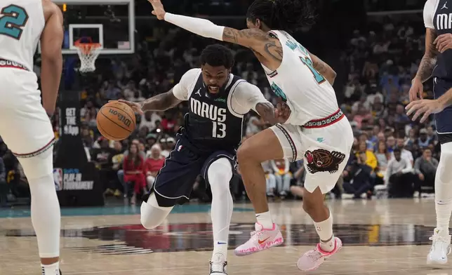 Dallas Mavericks forward Naji Marshall (13) dribbles the ball past Memphis Grizzlies guard Ja Morant, right, during the second half of an NBA play-in tournament basketball game Friday, April 18, 2025, in Memphis, Tenn. (AP Photo/George Walker IV)