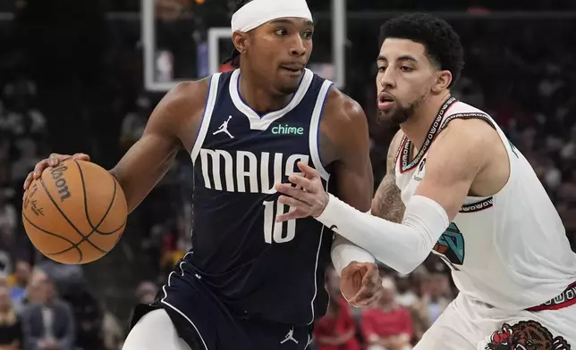 Dallas Mavericks guard Brandon Williams (10) dribbles the ball past Memphis Grizzlies guard Scotty Pippen Jr. (1) during the second half of an NBA play-in tournament basketball game Friday, April 18, 2025, in Memphis, Tenn. (AP Photo/George Walker IV)