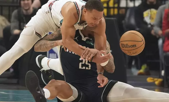 Memphis Grizzlies guard Desmond Bane (22) battles Dallas Mavericks forward P.J. Washington (25) for a loose ball during the first half of an NBA play-in tournament basketball game Friday, April 18, 2025, in Memphis, Tenn. (AP Photo/George Walker IV)