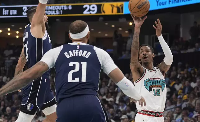 Memphis Grizzlies guard Ja Morant (12) shoots the ball past Dallas Mavericks forward Caleb Martin (16) and center Daniel Gafford (21) during the first half of an NBA play-in tournament basketball game Friday, April 18, 2025, in Memphis, Tenn. (AP Photo/George Walker IV)