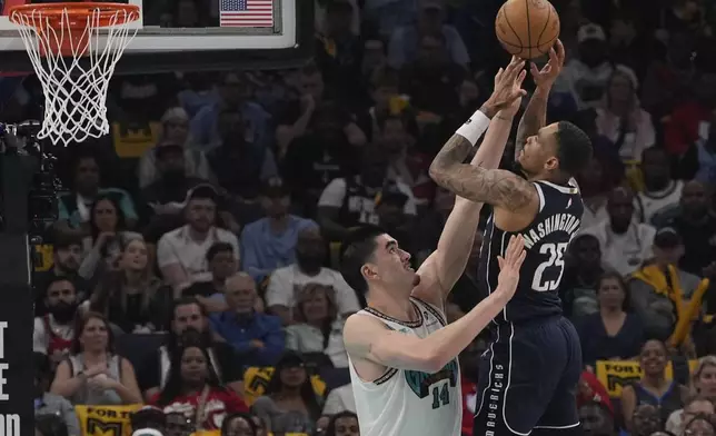 Dallas Mavericks forward P.J. Washington (25) shoots the ball over Memphis Grizzlies center Zach Edey (14) during the first half of an NBA play-in tournament basketball game Friday, April 18, 2025, in Memphis, Tenn. (AP Photo/George Walker IV)