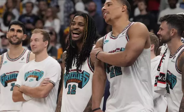 Memphis Grizzlies guard Ja Morant (12) and guard Desmond Bane (22) celebrate late in the second half of an NBA play-in tournament basketball game against the Dallas Mavericks, Friday, April 18, 2025, in Memphis, Tenn. (AP Photo/George Walker IV)