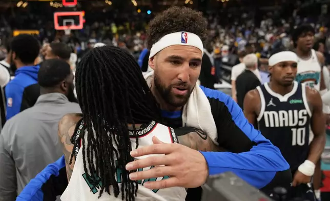 Dallas Mavericks guard Klay Thompson, right, hugs Memphis Grizzlies guard Ja Morant after an NBA play-in tournament basketball game Friday, April 18, 2025, in Memphis, Tenn. (AP Photo/George Walker IV)