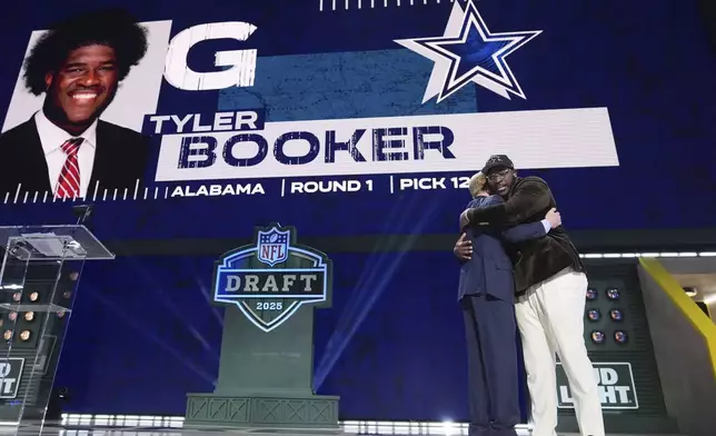 Alabama offensive lineman Tyler Booker, right, celebrates with NFL Commissioner Roger Goodell after being chosen by the Dallas Cowboys with the 12th overall pick during the first round of the NFL football draft, Thursday, April 24, 2025, in Green Bay, Wis. (AP Photo/Jeff Roberson)