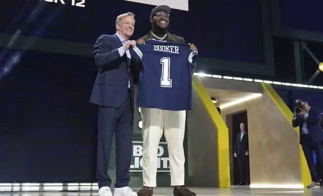 Alabama offensive lineman Tyler Booker, right, poses with NFL Commissioner Roger Goodell after being chosen by the Dallas Cowboys with the 12th overall pick during the first round of the NFL football draft, Thursday, April 24, 2025, in Green Bay, Wis. (AP Photo/Jeff Roberson)