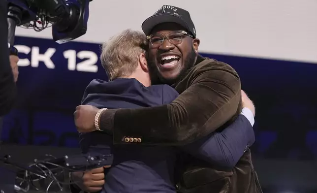 Alabama offensive lineman Tyler Booker, right, celebrates with NFL Commissioner Roger Goodell after being chosen by the Dallas Cowboys with the 12th overall pick during the first round of the NFL football draft, Thursday, April 24, 2025, in Green Bay, Wis. (AP Photo/Jeff Roberson)