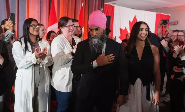 NDP Leader Jagmeet Singh, center, walks with his wife Gurkiran Kaur as he arrives to address supporters on election night, in Burnaby, B.C., on Monday, April 28, 2025. (Darryl Dyck/The Canadian Press via AP)