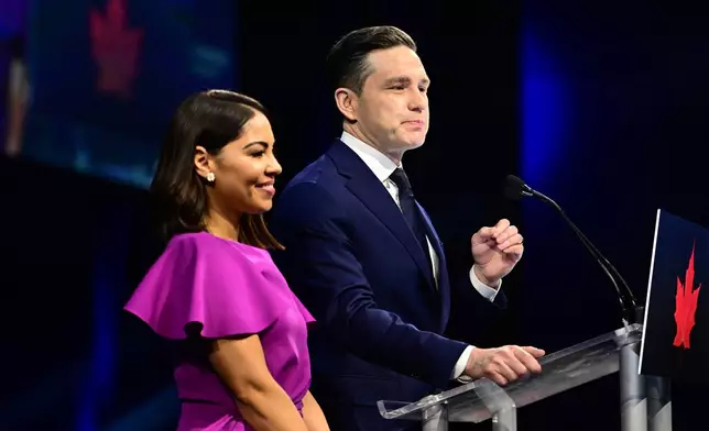 Conservative Leader Pierre Poilievre speaks to supporters with his wife Anaida Poilievre at his campaign headquarters on election night, in Ottawa, Tuesday, April 29, 2025. (Spencer Colby/The Canadian Press via AP)