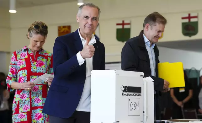 Canada's new Prime Minister and Liberal Leader Mark Carney votes with his wife Diana Fox Carney in Ottawa, Ontario, Monday, April 28, 2025. (Sean Kilpatrick/The Canadian Press via AP)