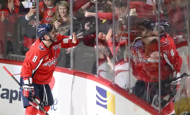 Washington Capitals left wing Alex Ovechkin (8) celebrating his 894th career goal with fans during the third period of an NHL hockey game against the Chicago Blackhawks, Friday, April 4, 2025, in Washington. (AP Photo/Nick Wass)