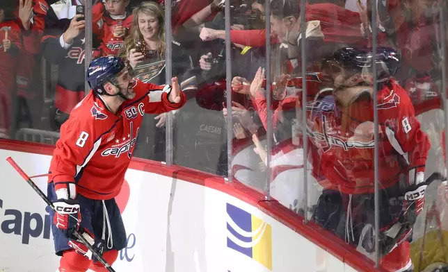 Washington Capitals left wing Alex Ovechkin (8) celebrating his 894th career goal with fans during the third period of an NHL hockey game against the Chicago Blackhawks, Friday, April 4, 2025, in Washington. (AP Photo/Nick Wass)