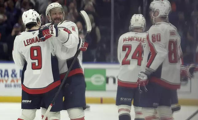 Washington Capitals left wing Alex Ovechkin (8), second left, celebrates after scoring his 895th career goal during the second period of an NHL hockey game against New York Islanders in Elmont, N.Y., Sunday, April 6, 2025. (AP Photo/Adam Hunger)