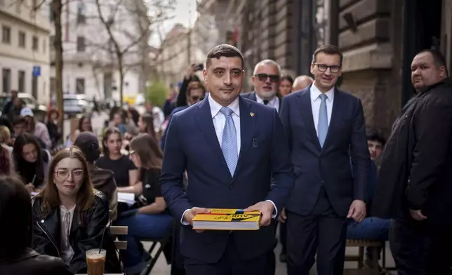 FILE - George Simion, the leader of Romania's most popular far-right party, the Alliance for the Union of Romanians (AUR), walks with former Polish Prime Minister Mateusz Morawiecki, right, in Bucharest, Romania, Friday, March 14, 2025, after filing his candidacy to participate in the country's presidential election rerun in May. (AP Photo/Vadim Ghirda, File)