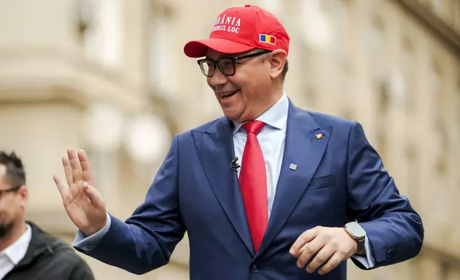 FILE - Victor Ponta, independent candidate in the upcoming presidential elections, wearing a cap that reads "Romania First" waves to supporters upon arriving to register his bid with the country's electoral authority in Bucharest, Romania, Wednesday, March 12, 2025. (AP Photo/Vadim Ghirda, File)