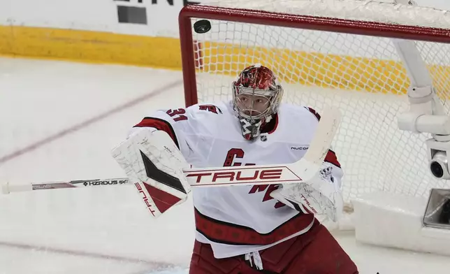 Carolina Hurricanes goaltender Frederik Andersen deflects a shot during the first period of Game 4 of an NHL hockey first-round series against the New Jersey Devils, Sunday, April 27, 2025, in Newark, N.J. (AP Photo/Seth Wenig)