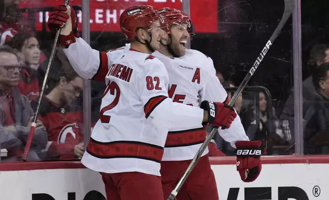 Carolina Hurricanes' Jaccob Slavin, right, celebrates his goal with Jesperi Kotkaniemi during the first period of Game 4 of an NHL hockey first-round series against the New Jersey Devils, Sunday, April 27, 2025, in Newark, N.J. (AP Photo/Seth Wenig)