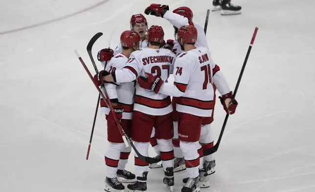 Carolina Hurricanes' Andrei Svechnikov (37), center, celebrates his goal with teammates during the first period of Game 4 of an NHL hockey first-round series against the New Jersey Devils, Sunday, April 27, 2025, in Newark, N.J. (AP Photo/Seth Wenig)