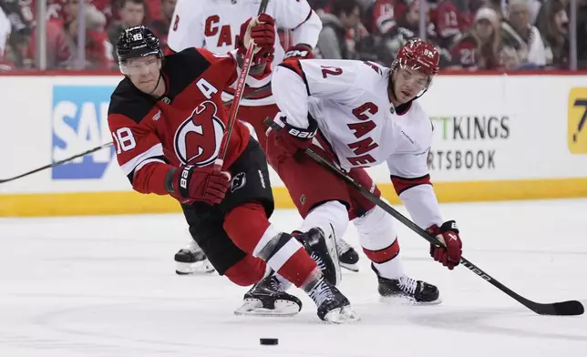 New Jersey Devils' Ondrej Palat, left, and Carolina Hurricanes' Jesperi Kotkaniemi compete for the puck during the first period of Game 4 of an NHL hockey first-round series, Sunday, April 27, 2025, in Newark, N.J. (AP Photo/Seth Wenig)