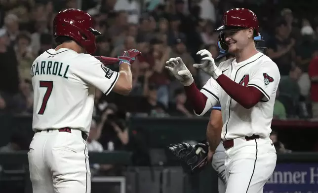Arizona Diamondbacks' Pavin Smith celebrates with Corbin Carroll (7) after hitting a two run home run against the Tampa Bay Rays in the third inning during a baseball game, Tuesday, April 22, 2025, in Phoenix. (AP Photo/Rick Scuteri)