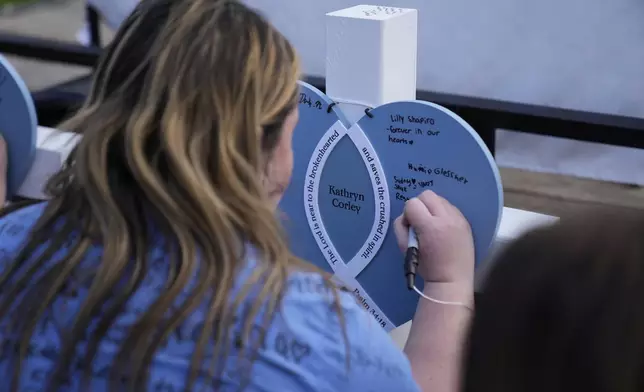 Notes are left on a heart for Kathryn Corley at a vigil for three young children and a teenager, including Corley, who were killed when a car barreled through a building used for an after-school camp Tuesday, April 29, 2025, in Chatham, Ill. (AP Photo/Erin Hooley)