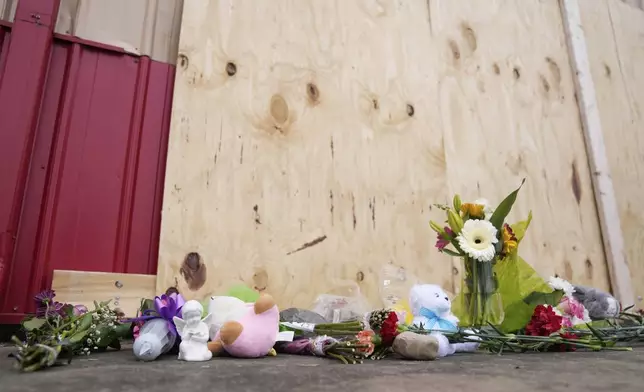 Flowers and other gifts are left at the scene after a car barreled through a building used for an after-school camp Tuesday, April 29, 2025, in Chatham, Ill. (AP Photo/Erin Hooley)