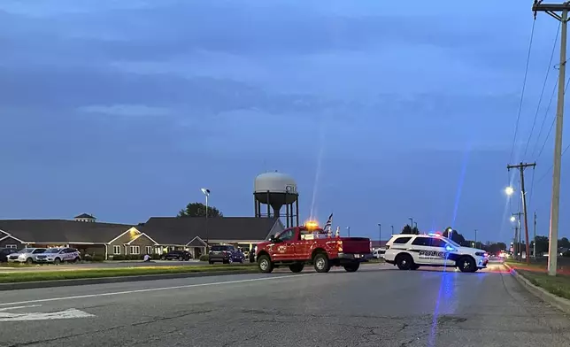 Emergency vehicles block a road leading to a building where a car smashed through during an after-school program, killing several people and injuring others, Monday, April 28, 2025, in Chatham, Ill. (AP Photo/John O'Connor)