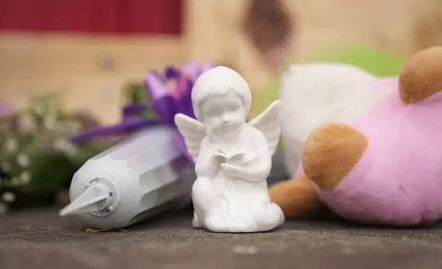 Flowers and other gifts are left at the scene after a car barreled through a building used for an after-school camp Tuesday, April 29, 2025, in Chatham, Ill. (AP Photo/Erin Hooley)