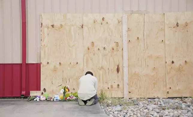 Harrison Allen, 14, kneels in prayer at the scene after a car barreled through a building used for an after-school camp Tuesday, April 29, 2025, in Chatham, Ill. (AP Photo/Erin Hooley)