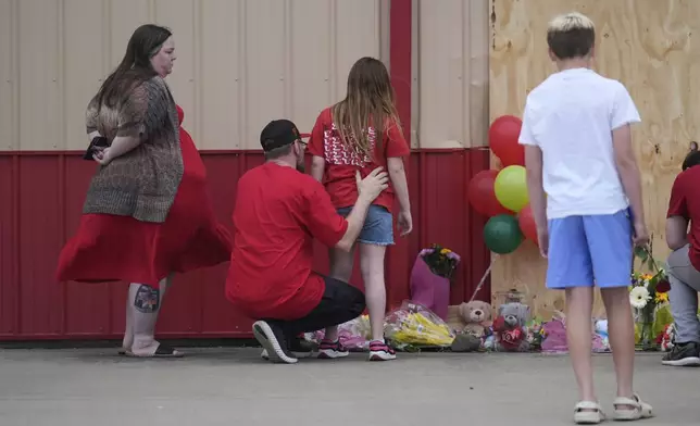 People leave balloons at the scene where a car barreled through a building used for an after-school camp Tuesday, April 29, 2025, in Chatham, Ill. (AP Photo/Erin Hooley)