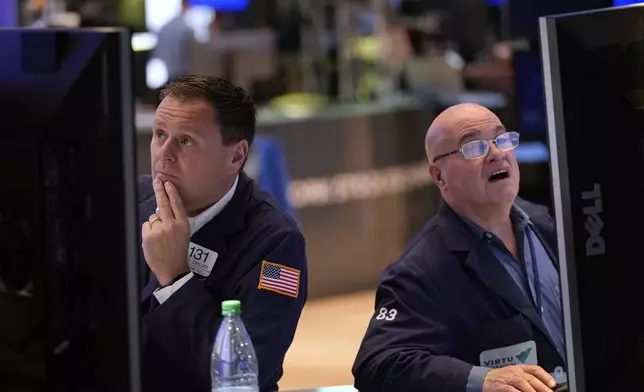 Matthew Cheslock, left, and Anthony Confusione work on the floor at the New York Stock Exchange in New York, Wednesday, April 30, 2025. (AP Photo/Seth Wenig)
