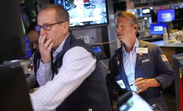 Bobby Charmak, right, works on the floor at the New York Stock Exchange in New York, Wednesday, April 30, 2025. (AP Photo/Seth Wenig)