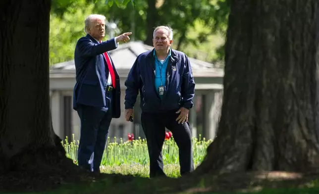 President Donald Trump, left, talks with Dale Haney, head White House groundskeeper, right, as he stands on the North Lawn of the White House in Washington, Wednesday, April 23, 2025, in Washington. (AP Photo/Mark Schiefelbein)