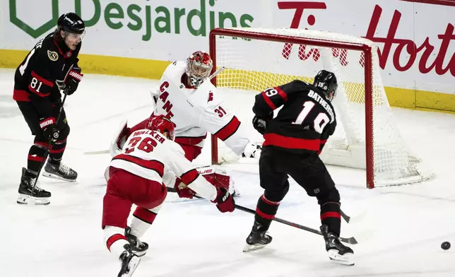 Ottawa Senators right wing Drake Batherson (19) misses the puck as Carolina Hurricanes goaltender Frederik Andersen (31) leaps into position during third-period NHL hockey game action in Ottawa, Ontario, Thursday, April 17, 2025. (Spencer Colby/The Canadian Press via AP)