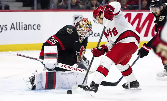 Carolina Hurricanes center Logan Stankoven, second from left, is stopped by Ottawa Senators goaltender Linus Ullmark (35) during first-period NHL hockey game action in Ottawa, Ontario, Thursday, April 17, 2025. (Spencer Colby/The Canadian Press via AP)