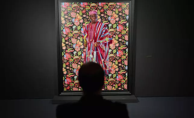 A visitor looks at a portrait of Oluṣẹgun Ọbasanjọ, former President of Nigeria, during the opening of American painter Kehinde Wiley's exhibition A Maze of Power in Mohammed VI Museum of Modern and Contemporary Art, in Rabat, Tuesday, April 15, 2025. (AP Photo/Mosa'ab Elshamy)