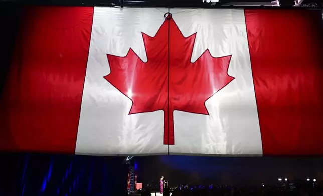 Conservative Leader Pierre Poilievre speaks to supporters with his wife Anaida Poilievre at his campaign headquarters on election night, in Ottawa, Tuesday, April 29, 2025. (Spencer Colby/The Canadian Press via AP)