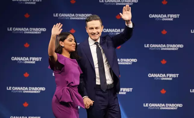 Conservative Leader Pierre Poilievre and his wife Anaida Poilievre arrive on stage at his campaign headquarters on election night, in Ottawa, Tuesday, April 29, 2025. (Adrian Wyld/The Canadian Press via AP)