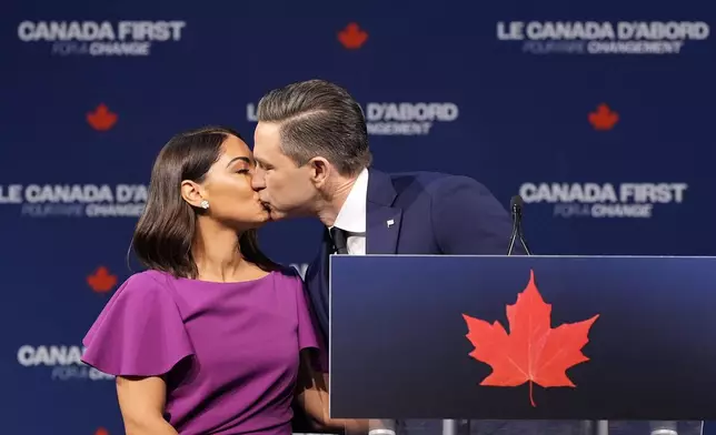 Conservative Leader Pierre Poilievre and his wife Anaida Poilievre kiss at his campaign headquarters on election night, in Ottawa, Tuesday, April 29, 2025. (Adrian Wyld/The Canadian Press via AP)