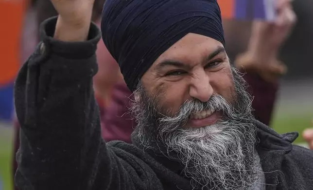 NDP Leader Jagmeet Singh reacts to passing cars during a sign waving campaign event with Port Moody-Coquitlam NDP candidate Bonita Zarrillo and volunteers on election day, in Port Moody, British Columbia on Monday, April 28, 2025. (Darryl Dyck/The Canadian Press via AP)