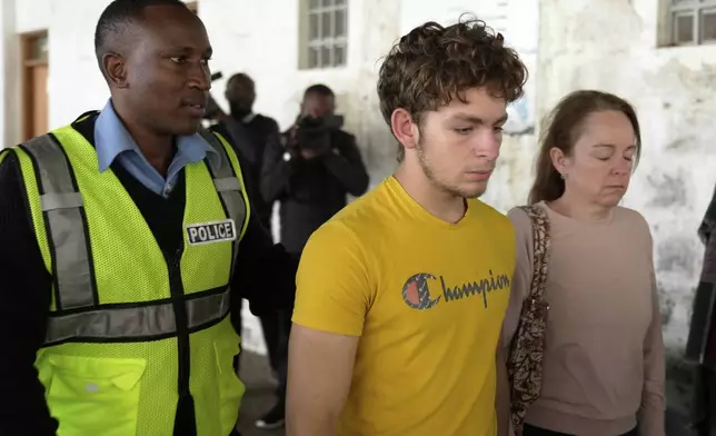 Belgian national Lornoy David, center, who admitted to charges related to the illegal possession and trafficking of live queen ants to sell as exotic pets, walks out of the Jomo Kenyatta International Airport Law Courts in Nairobi, Kenya Wednesday, April 23, 2025. (AP Photo/Brian Inganga)